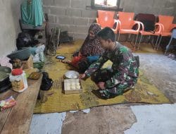 Anggota satgas TMMD bantu ibu ibu buat kue