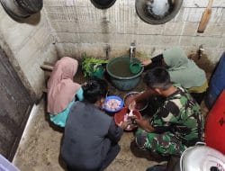 Anggota Satgas Membantu Ibu Asuh Memotong Daging Ayam