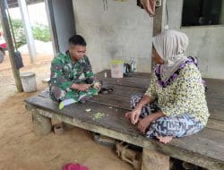 Anggota satgas TMMD bantu ibu asuh mengupas buah sekalian melaksanakan komsos