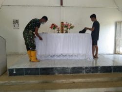 Anggota Satgas Membantu Warga Bersihkan Gereja