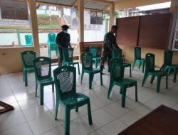 Anggota satgas TMMD bantu susun kursi di aula kantor desa setangau jaya