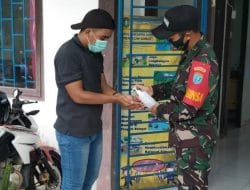 Anggota Satgas Menyemprotkan Handsanitizer Kepada Warga