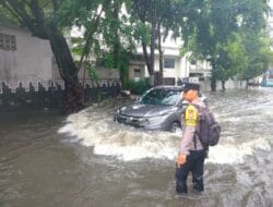 Aksi Humanis Bhabinkamtibmas Srengseng Saat Hujan Deras Genangi Jalan Depan SDN 05 Kembangan
