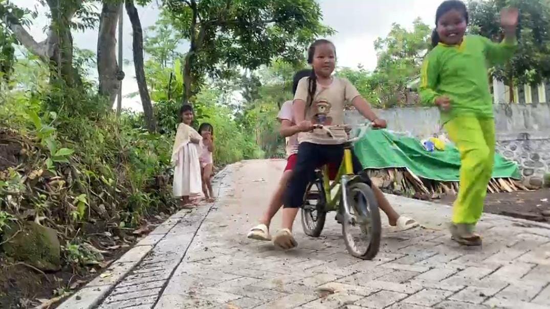 Keceriaan Anak Dusun Klagin Bersepeda di Atas Paving Baru TMMD Ke-128 yang Rampung 100 Persen